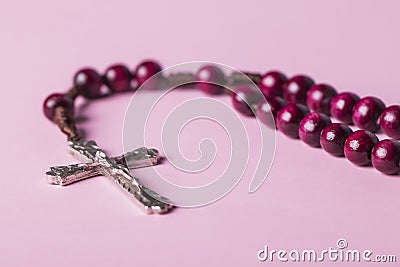 Rosary on a pink background. Cross. Stock Photo