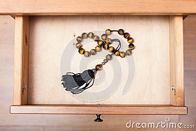 Rosary from tigers eye gemstone in open drawer Stock Photo