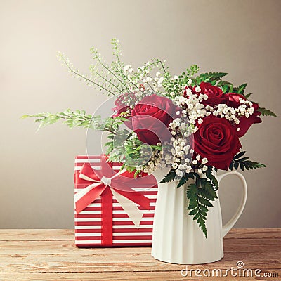 Rose flower bouquet and gift box on wooden table Stock Photo