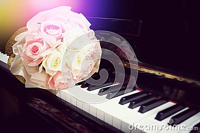 Rose flower in bouquet on keyboard of piano with light flare Stock Photo