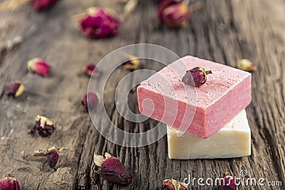 Natural hand made soap with dry pink roses on vintage wooden board. Spa Stock Photo
