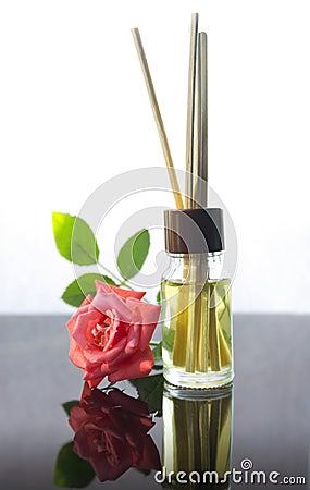 Rose scented oil bottle with wooden sticks on white Stock Photo