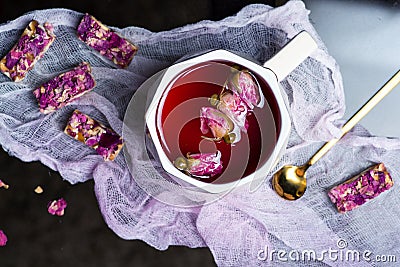 Rose tea with candy made of natural flowers and peanuts Stock Photo