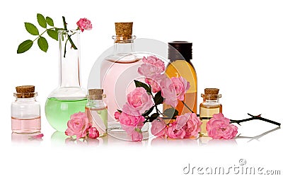 Rose water and essential perfume oil bottled and fresh pink flowers isolated on white background Stock Photo