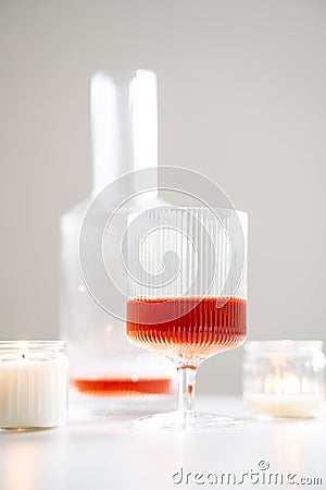 Rose wine in trendy ribbed wineglasses and decanter on white table Stock Photo