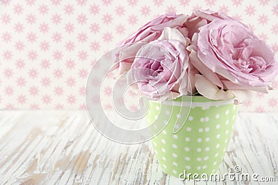 Roses in a green polkadot vase on vintage Stock Photo