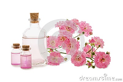 Roses water or oil in glass bottles and pink flowers isolated on white Stock Photo