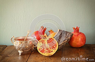 Rosh hashanah (jewesh holiday) concept - shofar, honey, apple and pomegranate over wooden table. traditional holiday symbols. Stock Photo