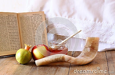 Rosh hashanah (jewesh holiday) concept - shofar, torah book, honey, apple and pomegranate over wooden table. traditional holiday Stock Photo