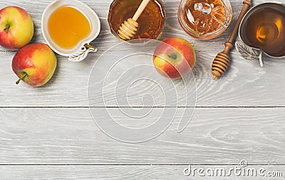 Rosh hashanah Jewish new year holiday celebration concept. Honey and apples over wooden background. Stock Photo