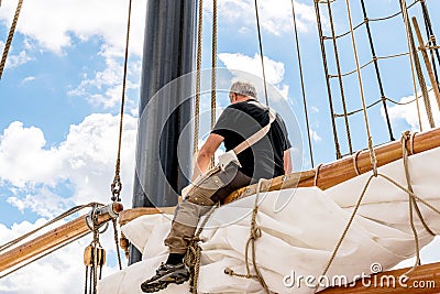 Rostock, Germany - August 2016: Sailor working on sailing ship. Editorial Stock Photo