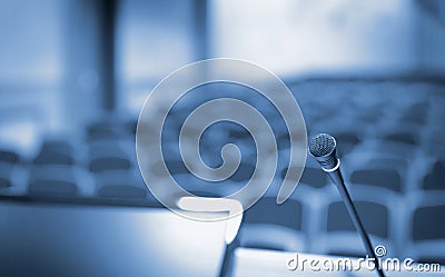 Rostrum with microphone and computer in conference hall, blue toned Stock Photo
