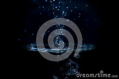 Rotating water vortex with drops and splashes blue color on a black background Stock Photo