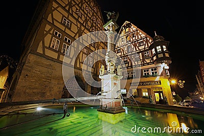 Historic buildings with fountain at the foreground at night in Rothenburg Ob Der Tauber, Germany. Editorial Stock Photo