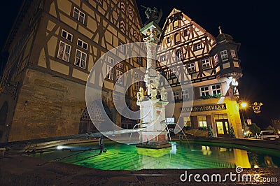 Historic buildings with fountain at the foreground at night in Rothenburg Ob Der Tauber, Germany. Editorial Stock Photo