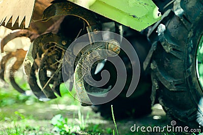 Rototiller of a walk-behind tractor close-up. Agricultural machinery for processing and care of the soil. Small tractor for Stock Photo