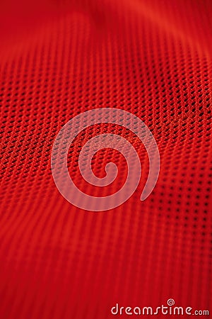 Close-up view of red fabric with grid-like pattern. Rough texture and black dots create striking contrast against red background. Stock Photo