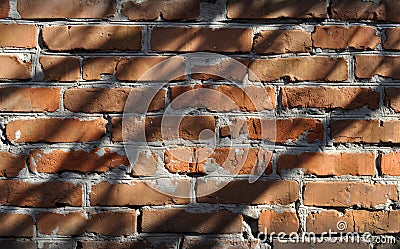 Roughly built red brick wall covered in shadow Stock Photo