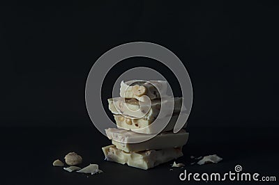 Roughly chopped pieces of white chocolate with walnuts set on top of each other with dark background Stock Photo