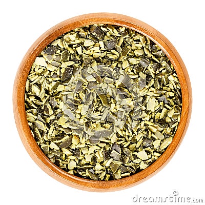 Roughly chopped raw pepita pumpkin seeds in wooden bowl over white Stock Photo