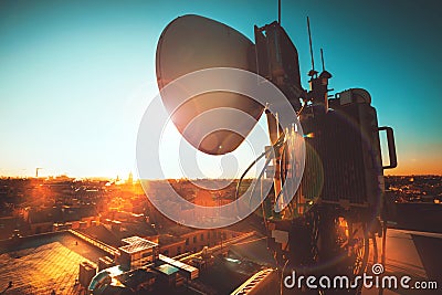 The round antenna on the roof of a building in the city at sunset Stock Photo