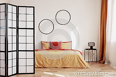 Round black frames on white wall of elegant bedroom interior with king size bed with yellow and ginger bedding Stock Photo