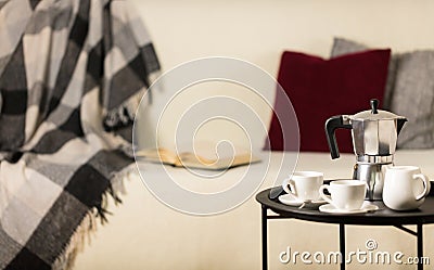 Round black metal coffee table with a coffee maker and a cup on Stock Photo