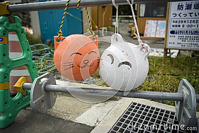 The round buoy is decorated with a cute cat face in color. And colorful In the village of Tashirojima Editorial Stock Photo