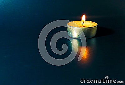 a round candle burns on a blue background Stock Photo