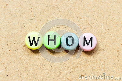 Round bead with black letter in word whom on wood background Stock Photo