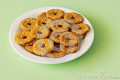 Round crackers with a hole and salt on a light green background Stock Photo