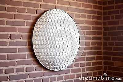 round decorative mirror hanging on a brick wall Stock Photo