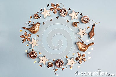 Round frame of golden Christmas decorations wit copy space on blue background. Stock Photo