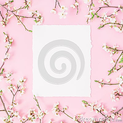 Round frame with spring flowers and white paper vintage car on pink background. Flat lay, top view. Stock Photo