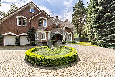 Round garden on driveway of english house in the forest during s Stock Photo