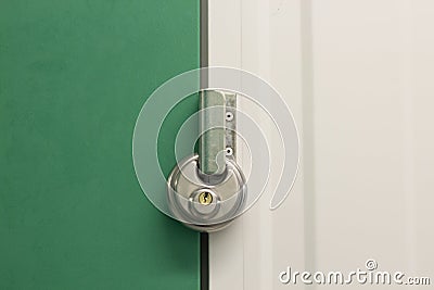 Round heavy duty pad lock on self storage unit Stock Photo