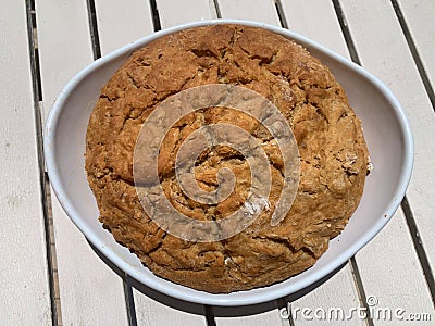 Round home made dark bread in a white plate. Horizontal image Stock Photo