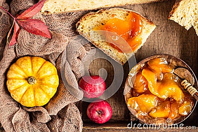 Round loaf of artisan wheat bread with pumpkin and apple in a wooden tray. Stock Photo