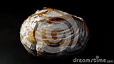 Round loaf of freshly baked bread in a dark environment Stock Photo