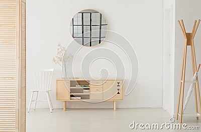 Round mirror above wooden cabinet, real photo with copy space Stock Photo