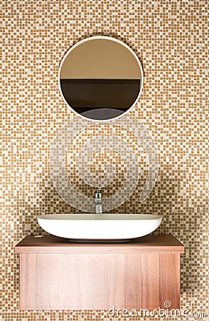 Round mirror with ceramic sink and silver tap Stock Photo