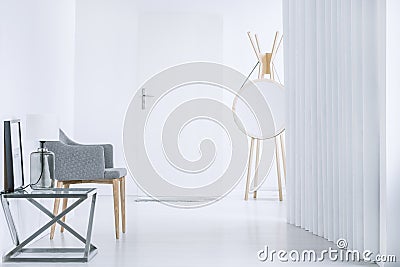 Round mirror and gray armchair Stock Photo