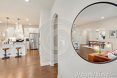 Round mirror reflective the interior of a modern residential home living room and kitchen Editorial Stock Photo