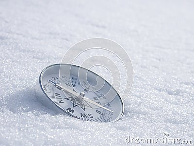 Round modern compass on the white snow, space for text. Concept for travelling and active lifestyle Stock Photo