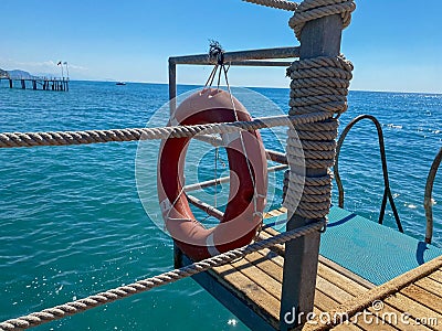 Round non-sinking red lifebuoy for safety to save the lives of drowning people tourists against the background of the sea in a Stock Photo