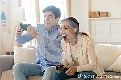 Excited emotional young family married couple playing console video games Stock Photo