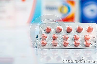 Round orange tablet pills in blister pack on doctor table or pharmacy counter. Drug use in daily life. Pharmaceutical industry. Stock Photo