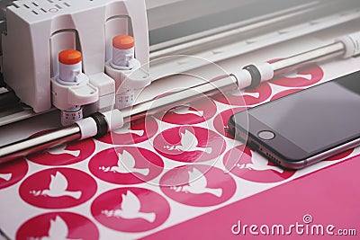round peace dove stickers are made by a computerized cutting machine from pink adhesive film Stock Photo