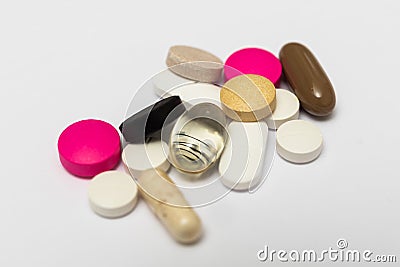 Round pills and oval hard and soft capsules on white background Stock Photo