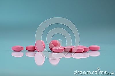 Round pink tablets pill on gradient background. Vitamins and minerals plus folic acid vitamin E and zinc in drug bottle Stock Photo